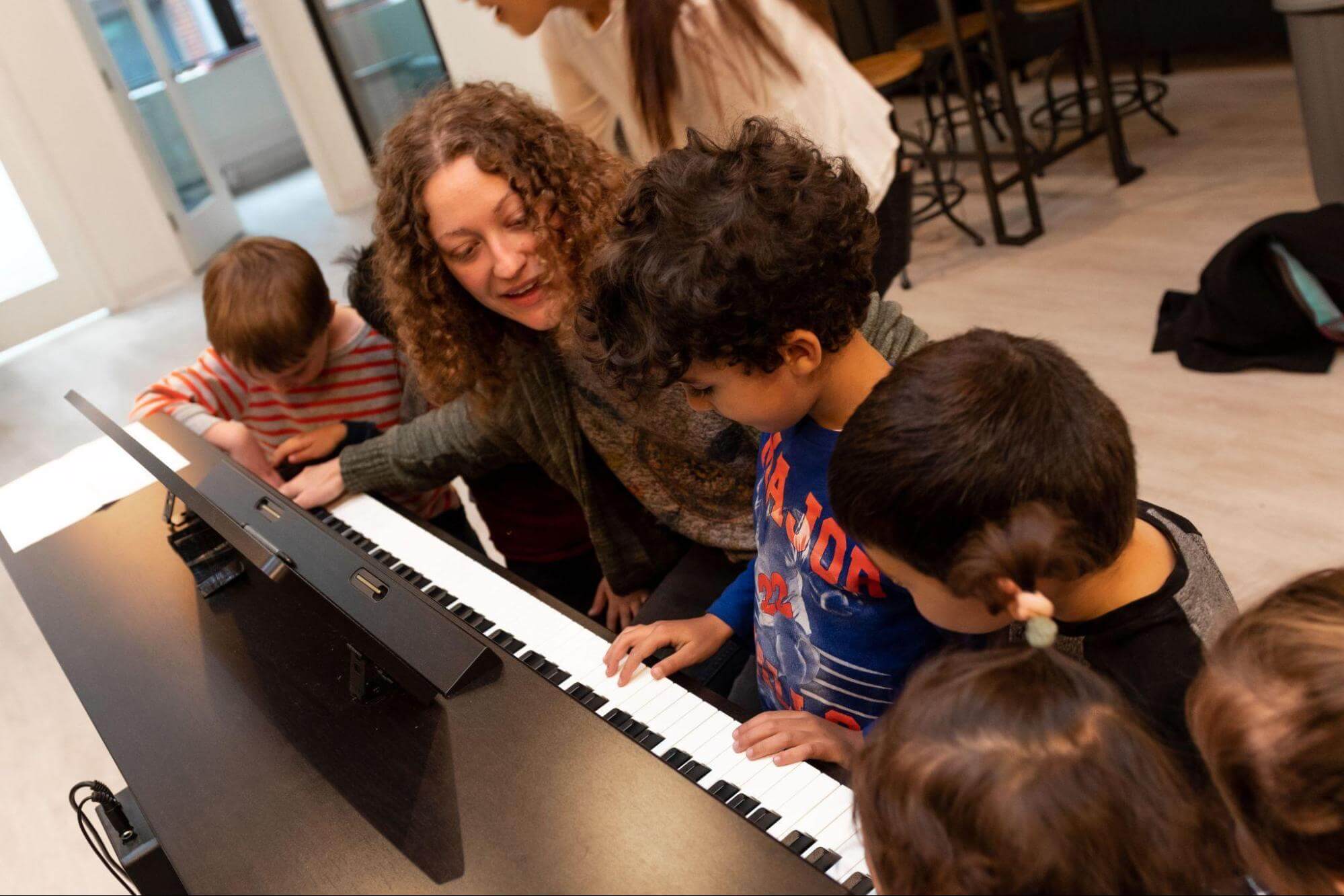 Kids learning piano in group lesson for children at music school in Boston MA